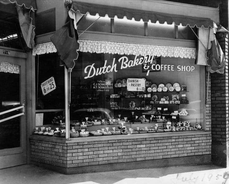A vintage black and white photo of the original store front that reads 